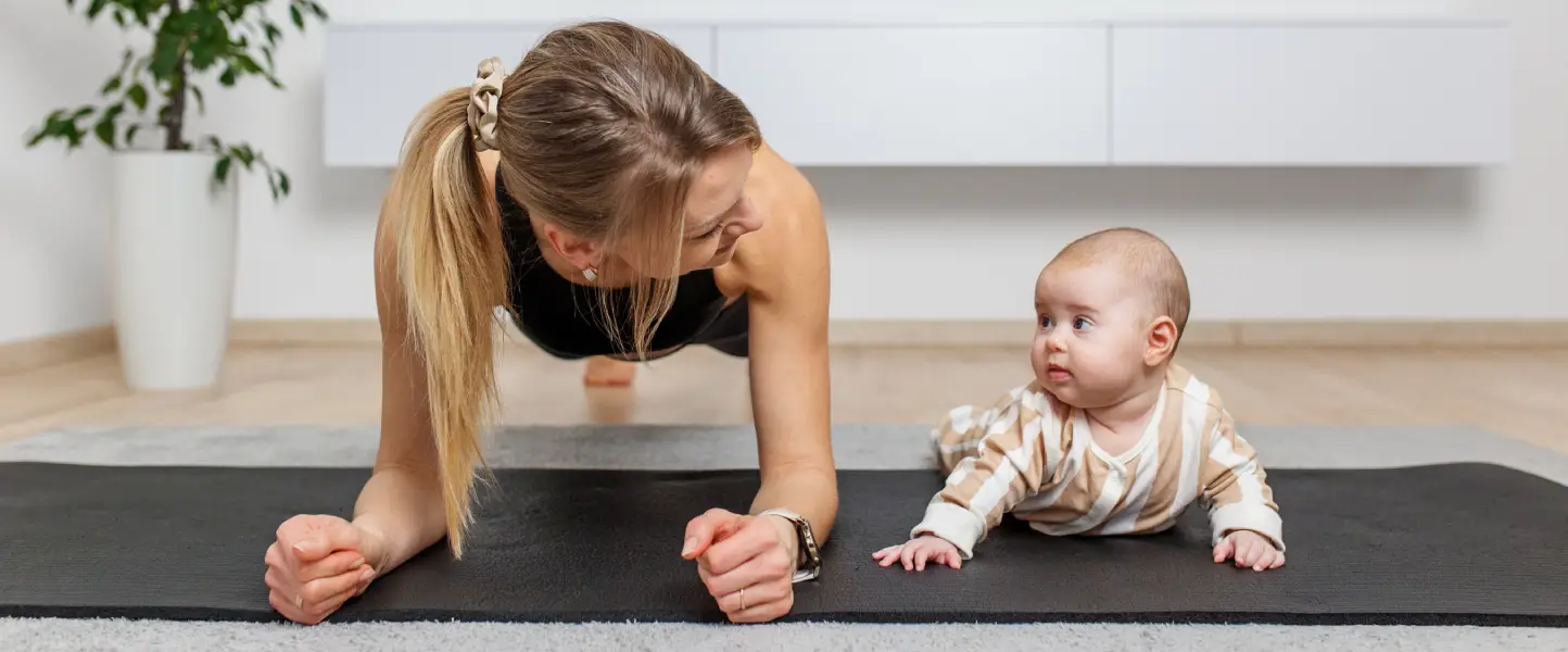 mother doing yoga with a newborn baby